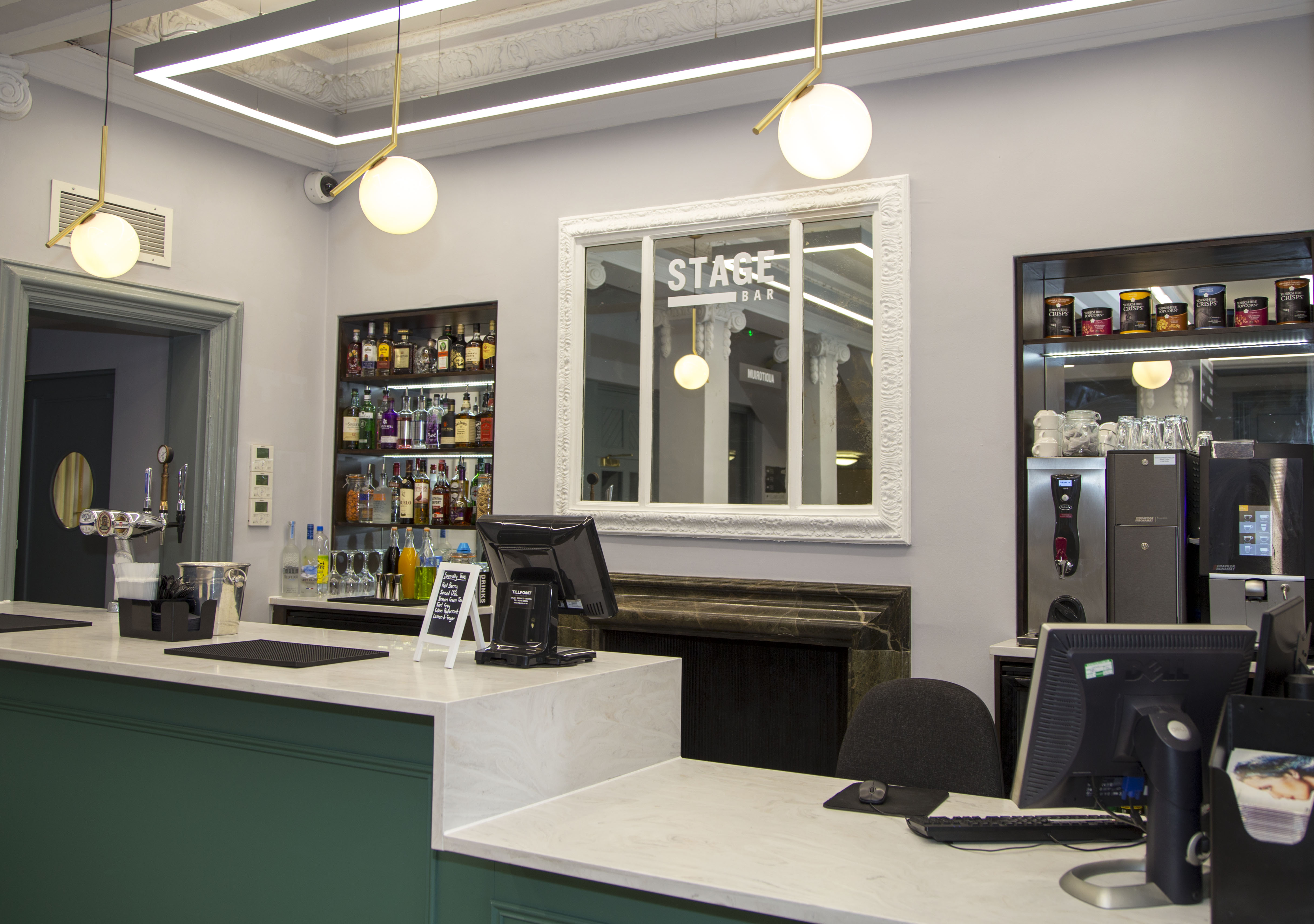 A bar area in the Winding Wheel foyer. It has a sophistocated look with green paint and 1920s themed globe lights hanging from the ceiling.